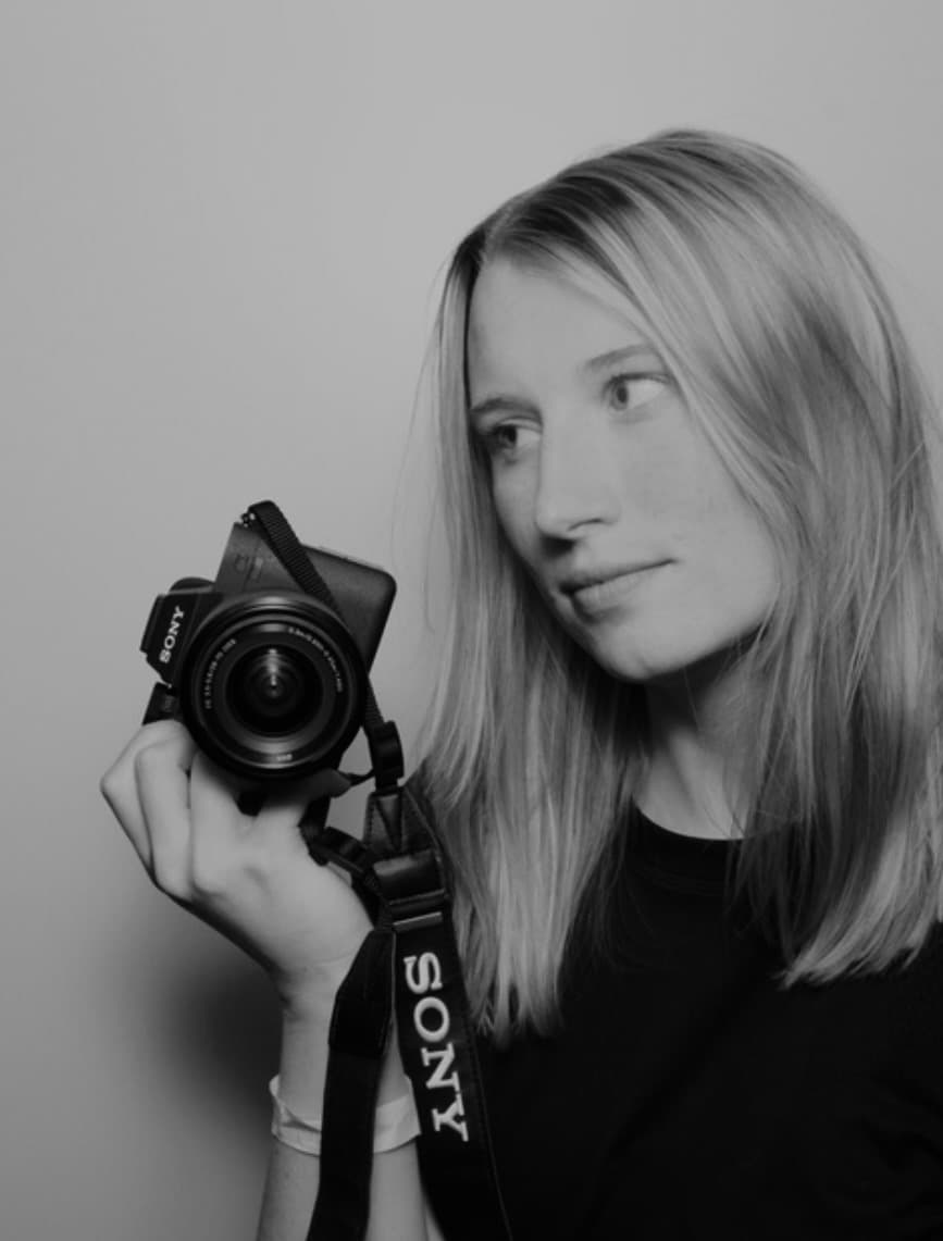 Kenzie holding her camera, black and white portrait