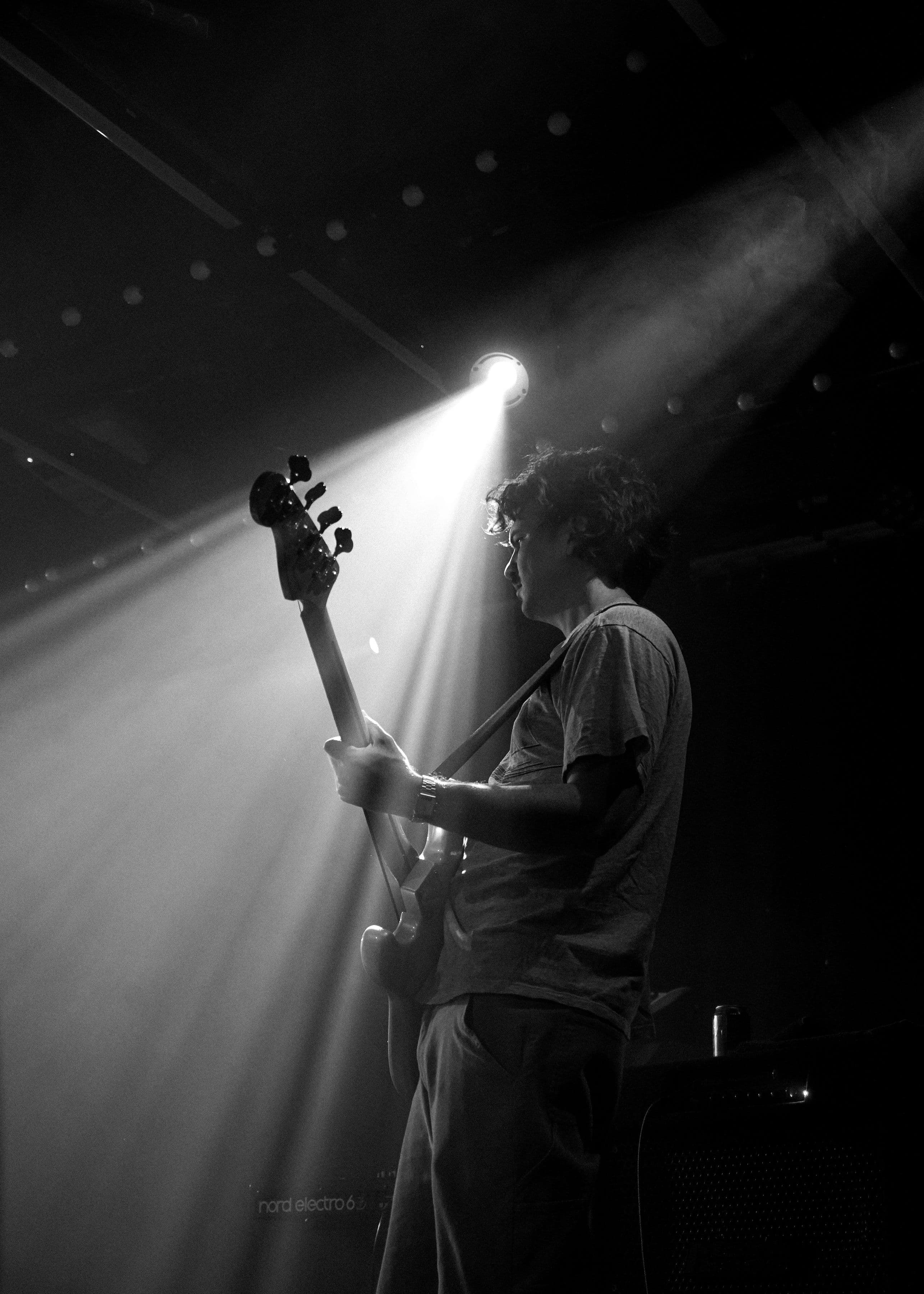 Winyah bassist under a spotlight in Birmingham, black and white